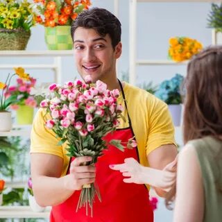 Florist selling flowers in a flower shop - License, download