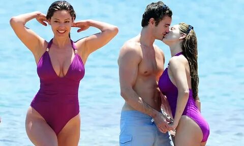 Kelly Brook back on smiling form as she smooches on sand in 
