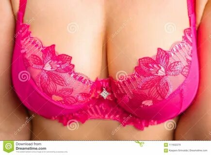 Photo about Close up photo of woman`s breasts in pink bra, big boobs. 