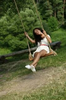 Happy woman riding on a swing in the park Stock Photo by © a
