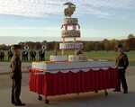 Two Marines watch over a Marine Corps Birthday cake prior to