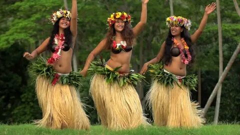 Barefoot Tahitian females in hula skirts and. - Royalty Free