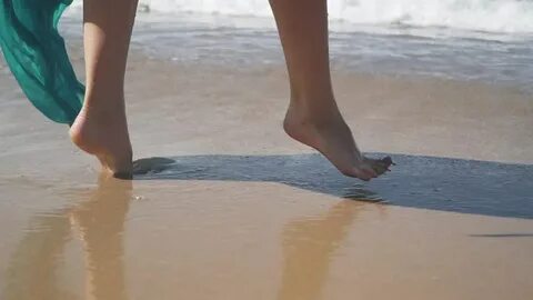Video Stok tourist walking barefoot on wet sand (100% Tanpa 