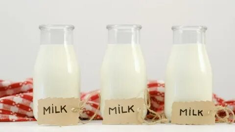 three milk bottles on white background Stok Videosu (%100 Te