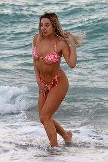 Tana Mongeau slips into a pink bikini during a fun day at th