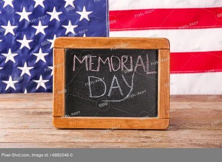 Chalkboard with text MEMORIAL DAY on table against USA flag 