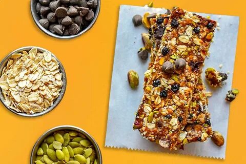 Overhead shot of homemade granola bars on parchment paper, surrounded by pi...