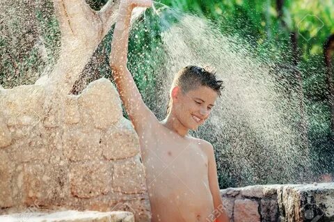 Young Boy Has A Shower On The Beach. Happy,Sunlight, Backlig