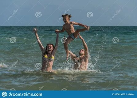 Mom, Dad and Daughter Swim, Play and Have Fun at the Sea in 
