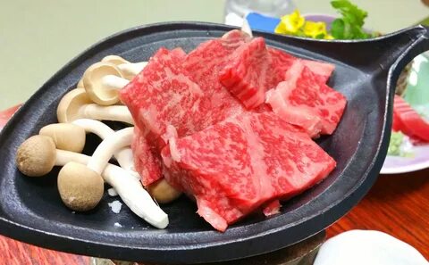 Large trays of paper thin kobe beef arrive at the table with sliced fresh v...