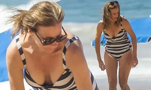 Rachel Griffiths looks chic in low-cut 50s style striped swi
