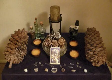 Yule altar with large pine cones, The Sun tarot card and gol