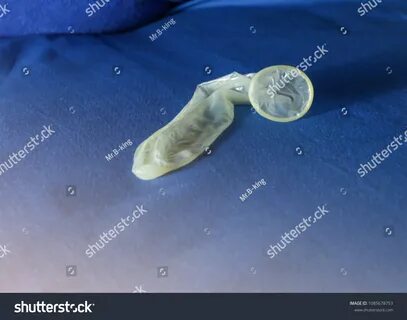 Used Condom On Blue Bed Sheet: стоковая фотография (редактир