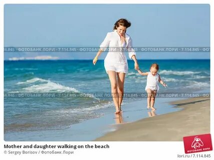 Mother and daughter walking on the beach. Стоковое фото № 71