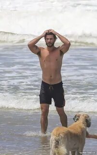 Liam Hemsworth shirtless in wet board shorts trail x12