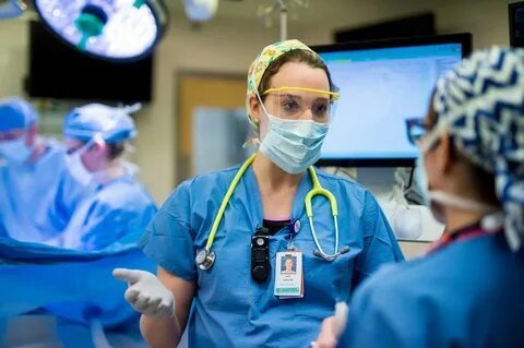 X. Kate Cohen, MD, anesthesiologist, speaks to a CRNA during a surgical pro...
