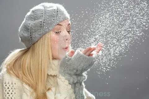 Teenage Girl Wearing Warm Winter Clothes And Hat Blowing Sno