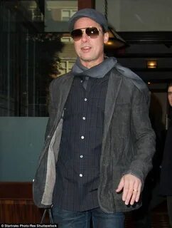 Brad Pitt carries a leather man bag and rocks a flat cap Bra