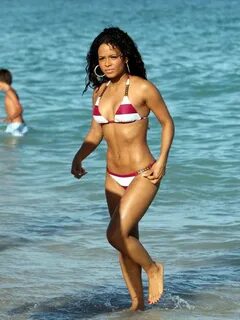 Young Christina Milian in striped bikini on a beach Celebs D