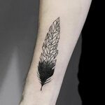 Geometric black and white feather tattoo on the right forear