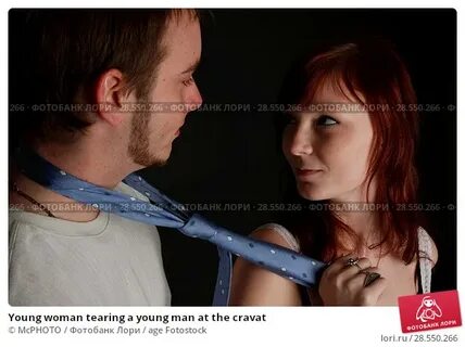 Young woman tearing a young man at the cravat. Стоковое фото