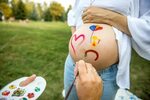 Drawing on the abdomen of a pregnant woman. Stock Photo by ©