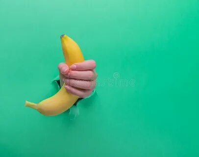 A Woman Holds a Banana in Her Hand, Inserted through a Hole 