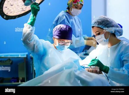 Surgeons operating a patient in operating room Stock Photo. 