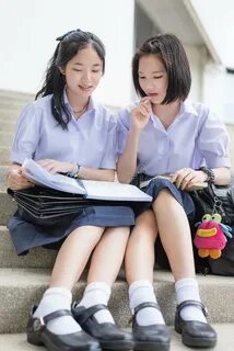 Тайский высокий студент школьницы в школьной форме сидит и б