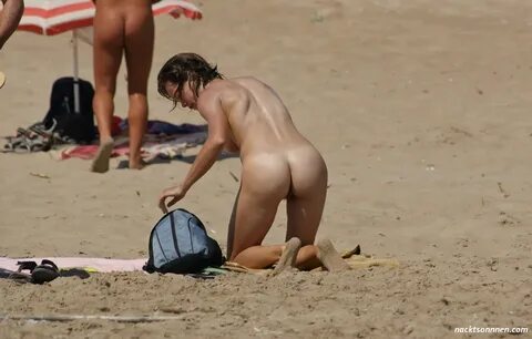 Eine junge Frau, verbringt einen sonnigen Tag, am FKK Strand. 