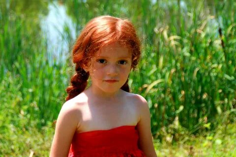 Baby girl with red hair on a background of lake free image d