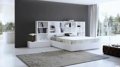 Dormitorio en blanco con estantería como cabecero Dormitorio