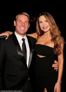 Shane Warne poses with busty brunette at poker tournament