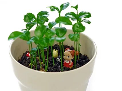 Small figures in a white ceramic pot with green plants free 