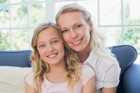 Glückliche Mutter und Tochter auf dem Sofa - Stockfotografie