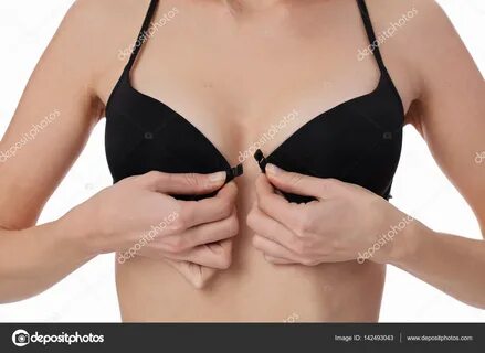 Woman taking off bra, wearing black underwear isolated on wh