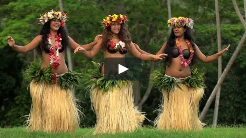 Polynesian girls in grass skirts and flower headdress dancin