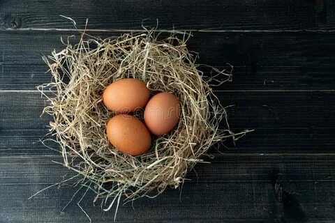 Fresh Brown Chicken Eggs in Hay Nest on Blue Wooden Backgrou