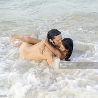 A Young Nude Couple Cuddle In The Oceans Surf Photography.