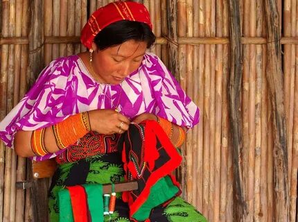 A woman on Isla Naluego works on a mola, a type of needlewor