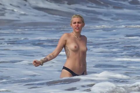 Miley Cyrus caught topless at the beach during the vacation 
