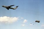 Parachutes open on supplies being dropped from a C-141B Star