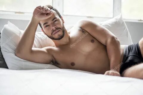 Genç bir Meksikalı adam beyaz yatakta gömleksiz - Stok Foto 