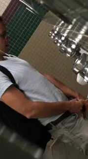 young guy pissing at urinal