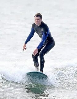 Colin Jost strips off to go surfing as he shakes off low Emm