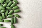зеленые таблетки хлориэлла на сером фоне пищевые добавки Сто