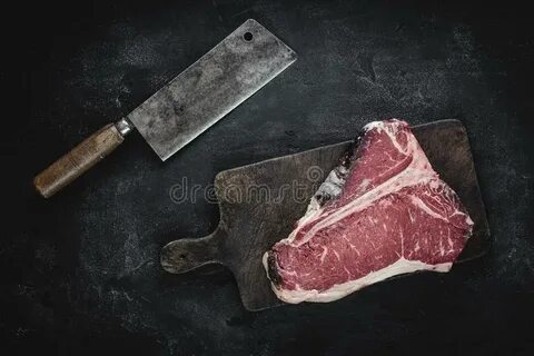 Raw Dry Aged T-bone Steak on Vintage Chopping Board with Mea