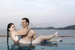 Man carrying woman in his arms in swimming pool Stock Photo 