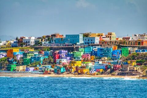 Bright colorful houses line the hills overlooking the beach 