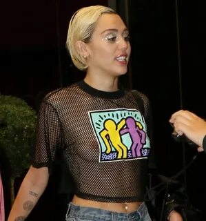 Sem sutiã, Miley Cyrus deixa seios à mostra em blusa transpa